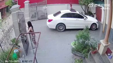 Žena otevírající bránu za větrného dne